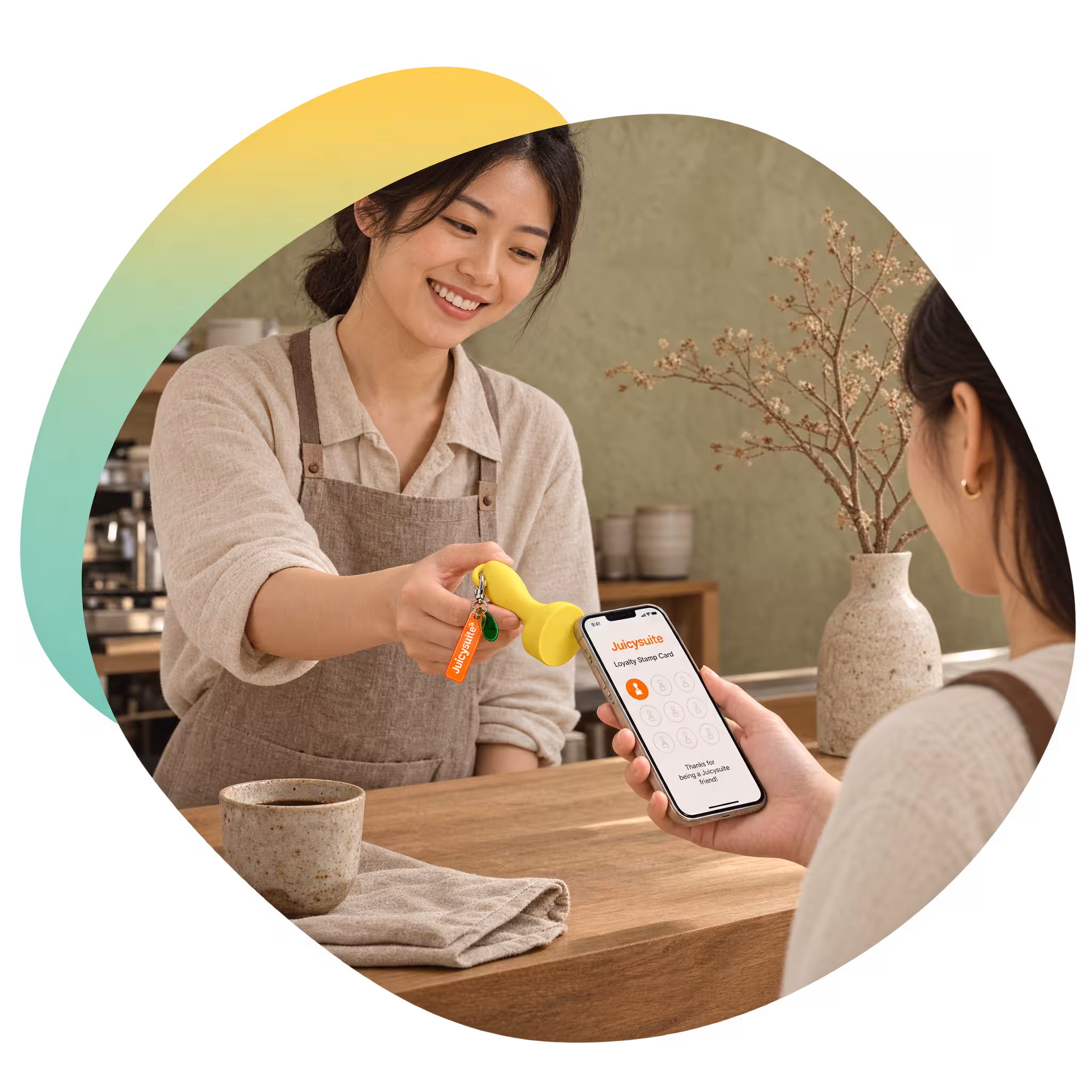 A barista at a counter pressing the yellow JuicySuite stamp against a customer's phone, the stamp card open on screen